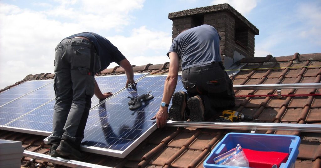 Das Solargesetz in Aktion: Handwerker installieren eine Solaranlage auf einem Dach